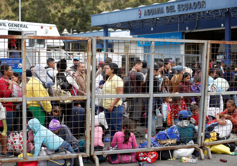 FILE PHOTO: Venezuelan citizens and other migrants wait at the border with Colombia, at the Rumichaca bridge checkpoint, in Ecuador