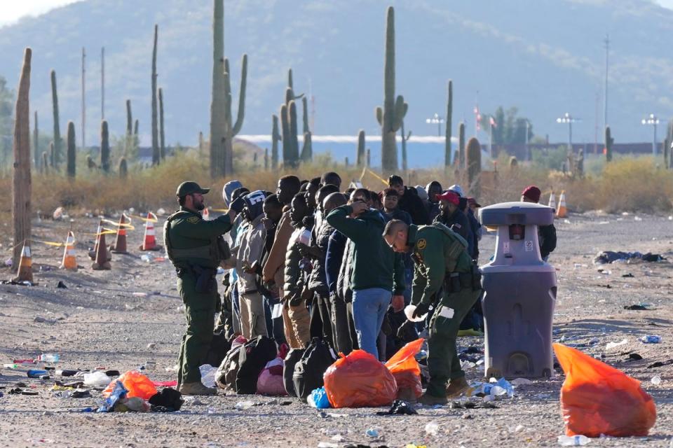 US Border Patrol officers with a group of migrants near the southern border (Associated Press)