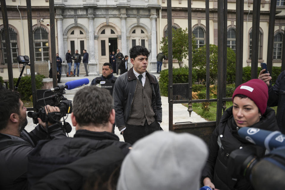 Sean Binderm, one of 24 aid workers and volunteers accused of participating in migrant rescue operations, stands at the gates of the court in Mytilene, on the northeastern Aegean island of Lesbos, Greece, Tuesday, Jan. 10, 2023. A Greek court was set to hear a smuggling-related criminal case Tuesday against a group of 24 aid workers and volunteers. The defendants deny all charges and say all they did was help rescue endangered people. International human rights groups have widely criticized the prosecution. (AP Photo/Panagiotis Balaskas)