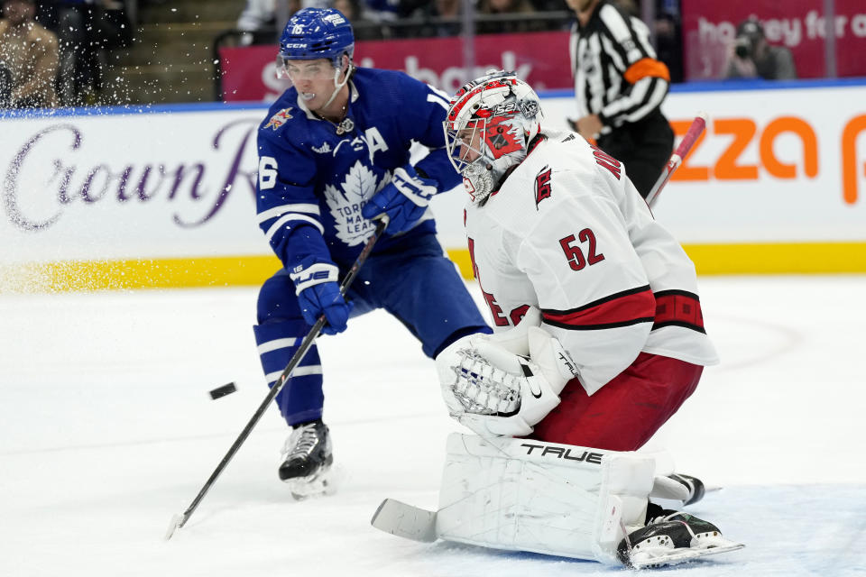 Toronto Maple Leafs right wing Mitchell Marner (16) looks on as Carolina Hurricanes goaltender Pyotr Kochetkov (52) makes a save during second-period NHL hockey game action in Toronto, Saturday, Dec. 30, 2023. (Frank Gunn/The Canadian Press via AP)