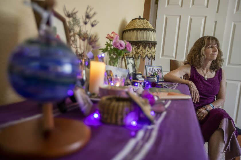 Penn Valley, CA - July 20: Portrait of End-of-life doula Akhila Murphy, 64, is one of the original co-founders of Full Circle of Living and Dying. Currently, she serves on the board of directors as Founding Director and Co-Chair President on Wednesday, July 20, 2022, in Penn Valley, CA. She is sitting next to a small alter she made for her mother. Akhila is a trained end-of-life doula and has been doing end-of-life care and after-death care for years. She helped her mother with end-of-life care in Akhila's home. (Francine Orr / Los Angeles Times)