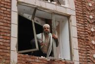 A Yemeni man looks from a damaged window at the site of a car bomb explosion near a mosque on July 29, 2015 in the capital Sanaa