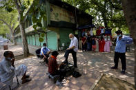 A man gets his shoes polished at the Janpath market in New Delhi, India, Monday, June 1, 2020. More states opened up and crowds of commuters trickled onto the roads in many of India's cities on Monday as a three-phase plan to lift the nationwide coronavirus lockdown started despite an upward trend in new infections. (AP Photo/Manish Swarup)