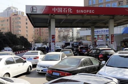 Vehicles are seen in queues as drivers wait to fill their tanks at a Sinopec gas station before the fuel price hike, in Zhengzhou, Henan province February 9, 2015. REUTERS/Stringer