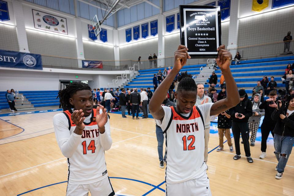North boys' basketball captains Teshaun Steele, left, and Joe Okla raise the championship plaque after the Polar Bears topped Leominster in the Central Mass. Class A championship.