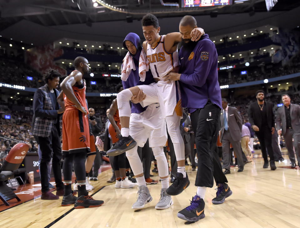Phoenix Suns guard Devin Booker is carried off the court by teammates during the fourth quarter of Tuesday’s game against the Toronto Raptors. (Nathan Denette/The Canadian Press via AP)