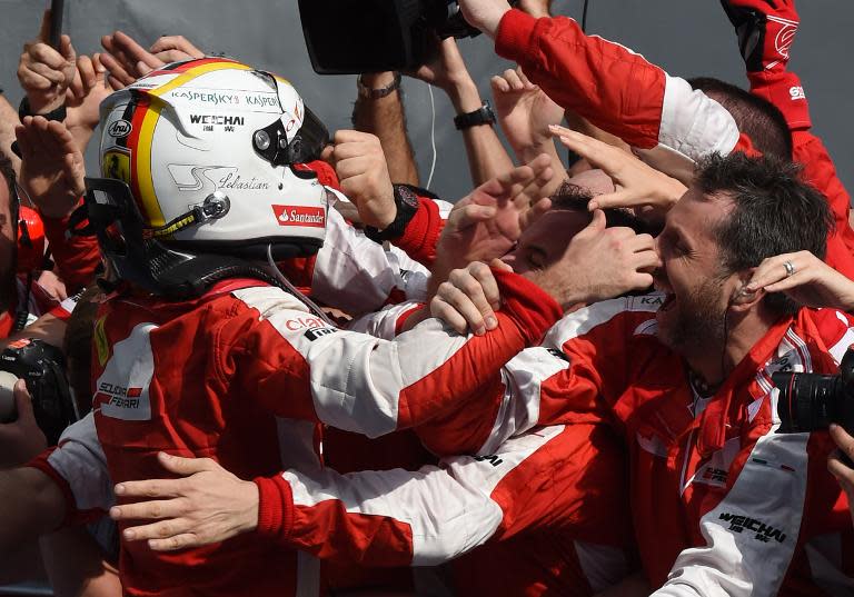 Sebastian Vettel (left) celebrates with team members after winning the Malaysian Grand Prix in Sepang on March 29, 2015