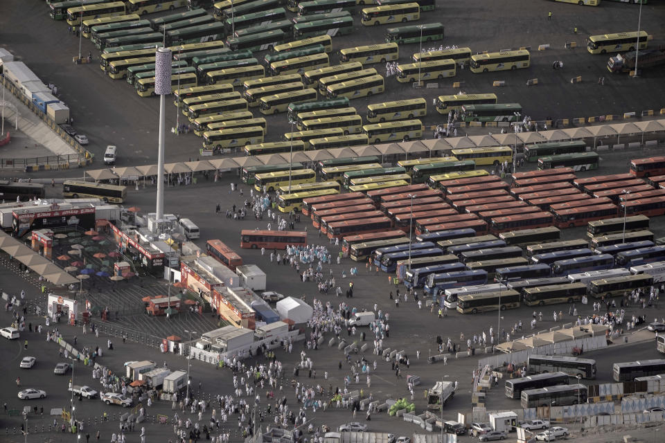 Dozens of buses park as pilgrims walk to enter the Grand Mosque, during the annual hajj pilgrimage, in Mecca, Saudi Arabia, Thursday, June 22, 2023. Muslim pilgrims are converging on Saudi Arabia's holy city of Mecca for the largest hajj since the coronavirus pandemic severely curtailed access to one of Islam's five pillars. (AP Photo/Amr Nabil)