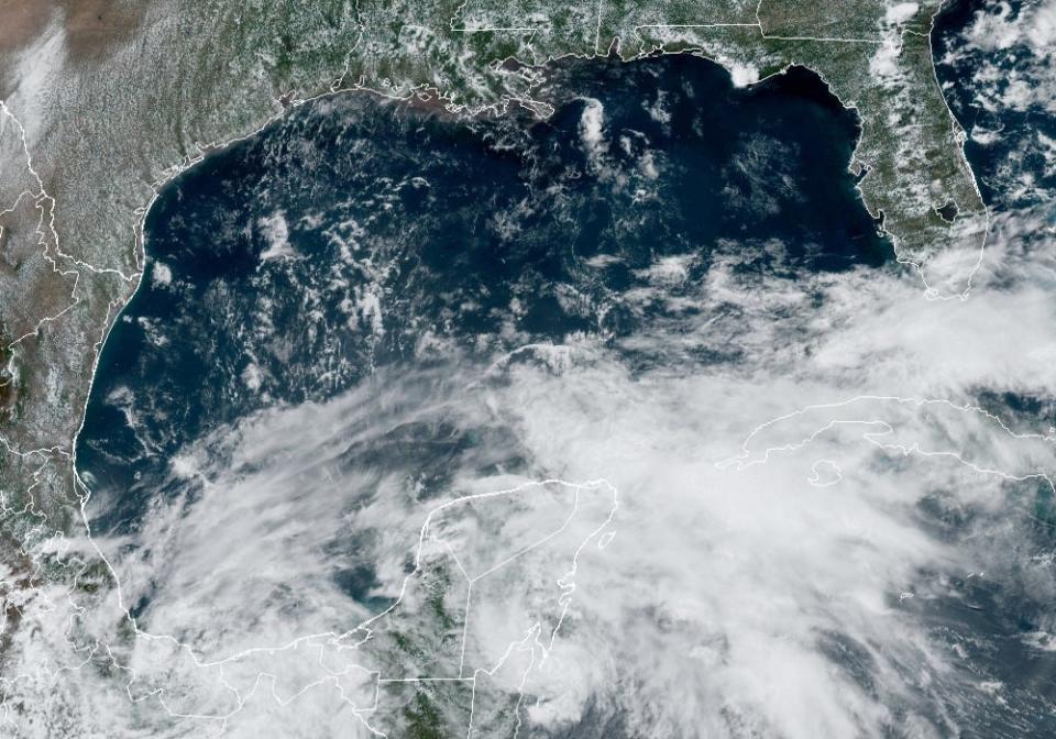 A low-pressure system was developing Tuesday near Mexico's Yucatan Peninsula, which could potentially become the first named storm of the Atlantic hurricane season. Texas is in the upper left corner of the satellite image.