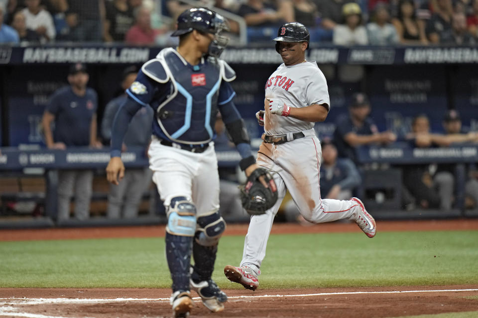 Boston Red Sox's Rafael Devers, right, scores behind Tampa Bay Rays catcher Christian Bethancourt on an RBI single by Adam Duvall during the fourth inning of a baseball game Monday, Sept. 4, 2023, in St. Petersburg, Fla. (AP Photo/Chris O'Meara)