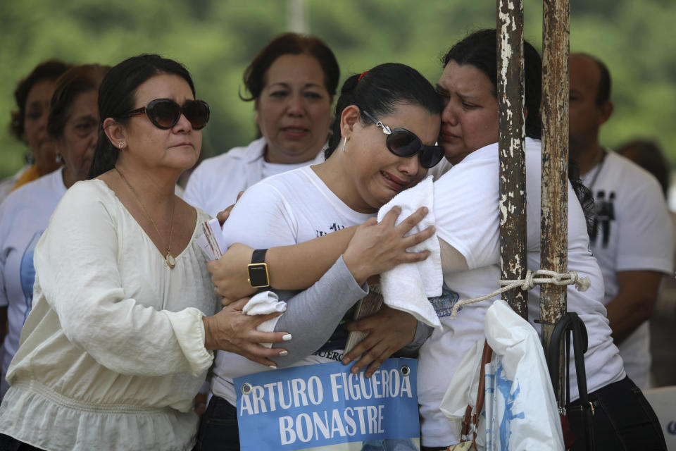 Basilia Bonastre, mother of Arturo Figueroa Bonastre, whose remains were found amid hundreds of others in clandestine graves, is consoled by friends during a Mass in Colinas de Santa Fe, Mexico, Monday, Oct. 15, 2018. The Mass was held one day before the women's Solecito Collective is honored by Notre Dame University for their work locating the remains of missing people in Veracruz state. The Solecito Collective is made up people searching for their missing loved ones. (AP Photo/Felix Marquez)
