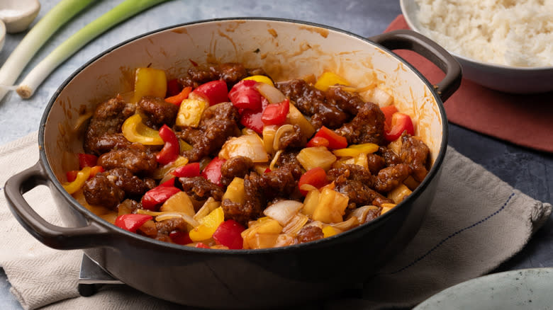 sweet and sour pork with peppers and pineapple in pan