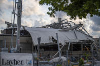 The roof of a construction machinery dealer lies across the building from severe weather in Paderborn, Germany, Friday, May 20, 2022. Meteorologists had warned that heavy rainfall and hail were expected in western and central Germany on Friday, with storms producing wind gusts up to 130 kph (81 mph). (Lino Mirgeler/dpa via AP)