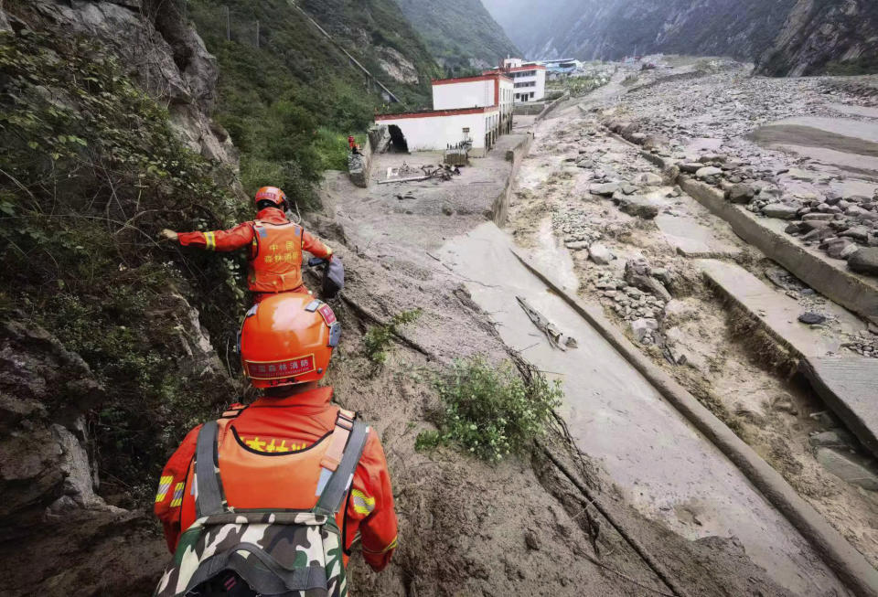 In this photo released by China's Xinhua News Agency, rescuers work at a landslide site in Miansi Township of Wenchuan County in southwestern China's Sichuan Province, Tuesday, June 27, 2023. Several people were found dead and others remained missing after landslides hit a county in China's southwestern Sichuan province on Tuesday, leading to authorities evacuating more than 900 people. (Xinhua via AP)