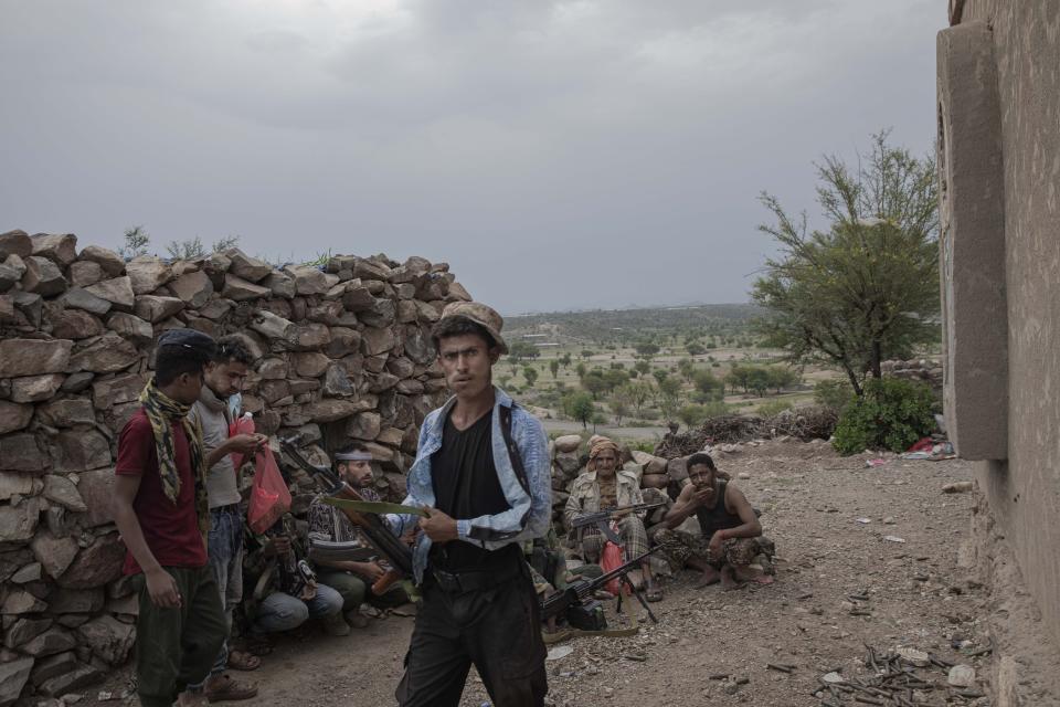 In this Monday, Aug. 5, 2019 photo, fighters from a militia known as the Security Belt, that is funded and armed by the United Arab Emirates, take cover at the Gabhet Hajr frontline with Houthi rebels, in Yemen's Dhale province. Yemen’s civil war has been deadlocked for months, with neither side making major gains. At one of the most active front lines, militiamen backed by the Saudi-led coalition are dug in, exchanging shelling every night with Iranian-allied Houthi rebels only a few hundred meters away. (AP Photo/Nariman El-Mofty)