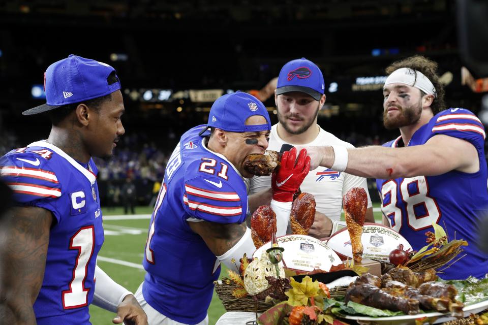 Buffalo Bills wide receiver Stefon Diggs (14), safety Jordan Poyer (21), quarterback Josh Allen (17) and tight end Dawson Knox (88) eat a Thanksgiving turkey while being interviewed after a game against the New Orleans Saints, Thursday, Nov. 25, 2021, in New Orleans. | Tyler Kaufman, Associated Press