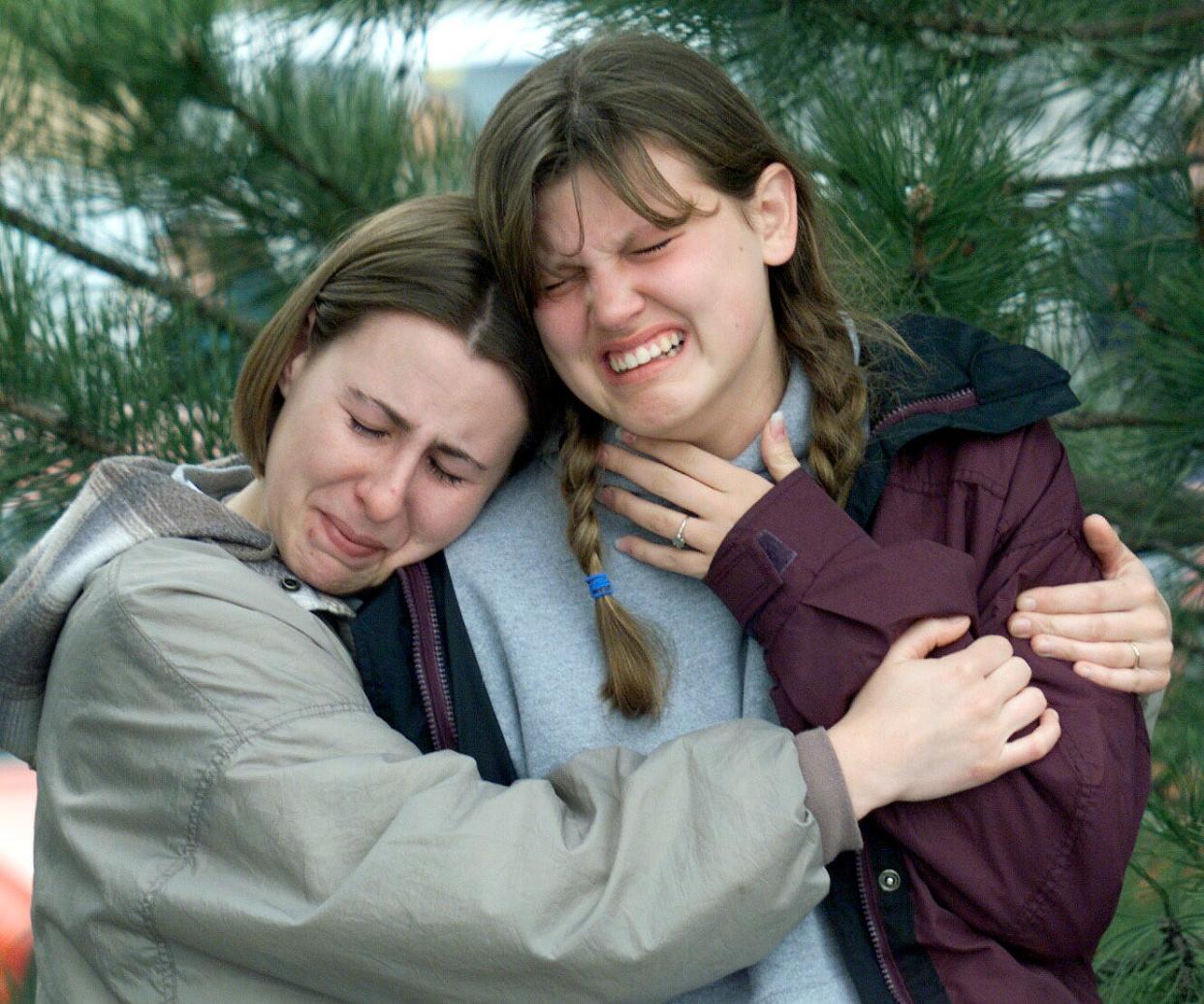 In this April 21 file photo, Shaleane Elliott, 21, a graduate of Columbine High, and Emily Stepp, 18, a senior at the school, weep for friends killed in the shooting at an impromptu memorial near the school in Littleton, Colorado.