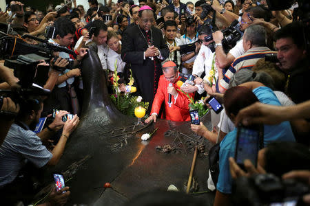 FILE PHOTO: Newly elevated Cardinal Gregorio Rosa Chavez prays at the grave of Mons. Oscar Arnulfo Romero upon his return at the Metropolitan Cathedral in San Salvador, El Salvador, July 4, 2017. REUTERS/Jose Cabezas/File Photo