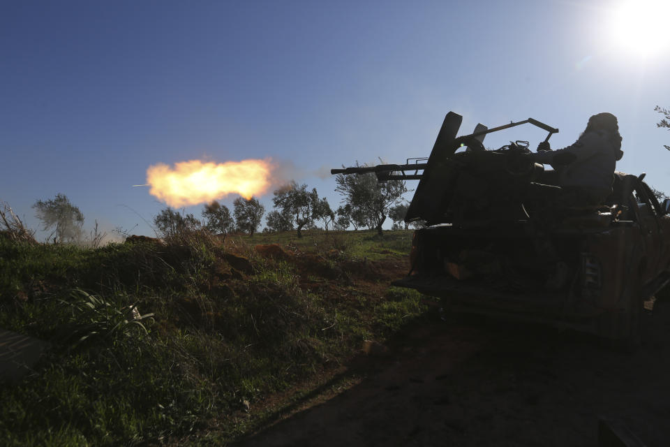 Turkish backed Syrian fighter fires at a frontline near the town of Saraqib in Idlib province, Syria, Wednesday, Feb. 26, 2020. Syrian government forces have captured dozens of villages, including major rebel strongholds, over the past few days in the last opposition-held area in the country's northwest. (AP Photo/Ghaith Alsayed)