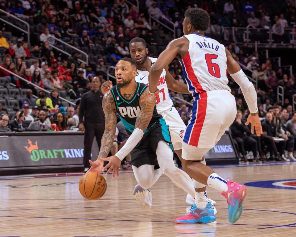 Portland Trail Blazers guard Damian Lillard (0) drives to the basket between Detroit Pistons forward Eugene Omoruyi (97) and guard Hamidou Diallo (6) during the fourth quarter on Monday's game.