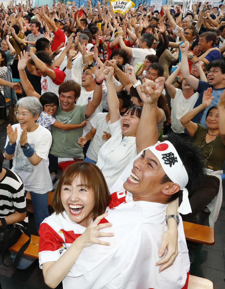 Spectators celebrate after Japan's Kenki Fukuoka scored a try during the Rugby World Cup Pool A game during a public-viewing event in Fukuoka western Japan, Saturday, Sept. 28, 2019. (Takuto Kaneko/Kyodo News via AP)