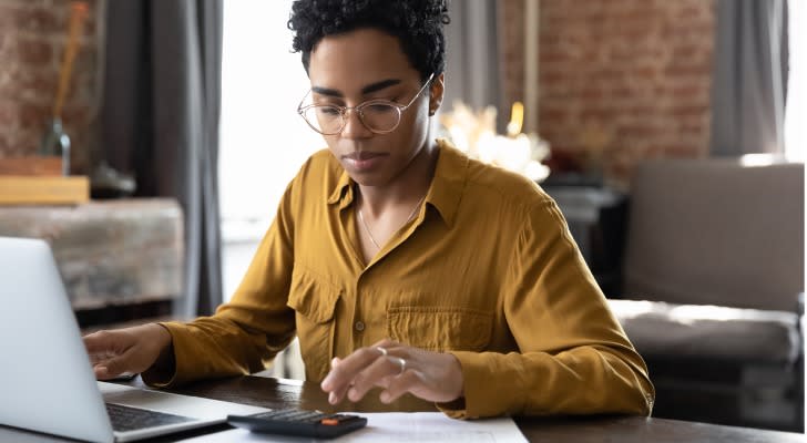 A woman calculating how much she will make in dividends if she invests her $100,000