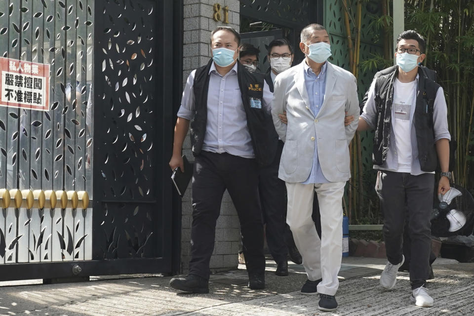 Hong Kong media tycoon Jimmy Lai, center, who founded local newspaper Apple Daily, is arrested by police officers at his home in Hong Kong, Monday, Aug. 10, 2020. Lai was arrested Monday on suspicion of collusion with foreign powers, his aide said, in the highest-profile use yet of the new national security law Beijing imposed on the city after protests last year. (AP Photo)