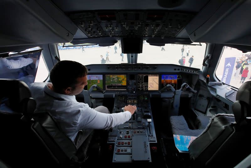 FILE PHOTO: A pilot sits in a cockpit of the Embraer E-195 E2 jet airliner at the MAKS 2019 air show in Zhukovsky, outside Moscow