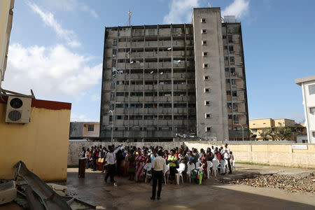 Congregants pray outside during a service after their church was destroyed by Cyclone Idai, in Beira, Mozambique, March 24, 2019. REUTERS/Siphiwe Sibeko