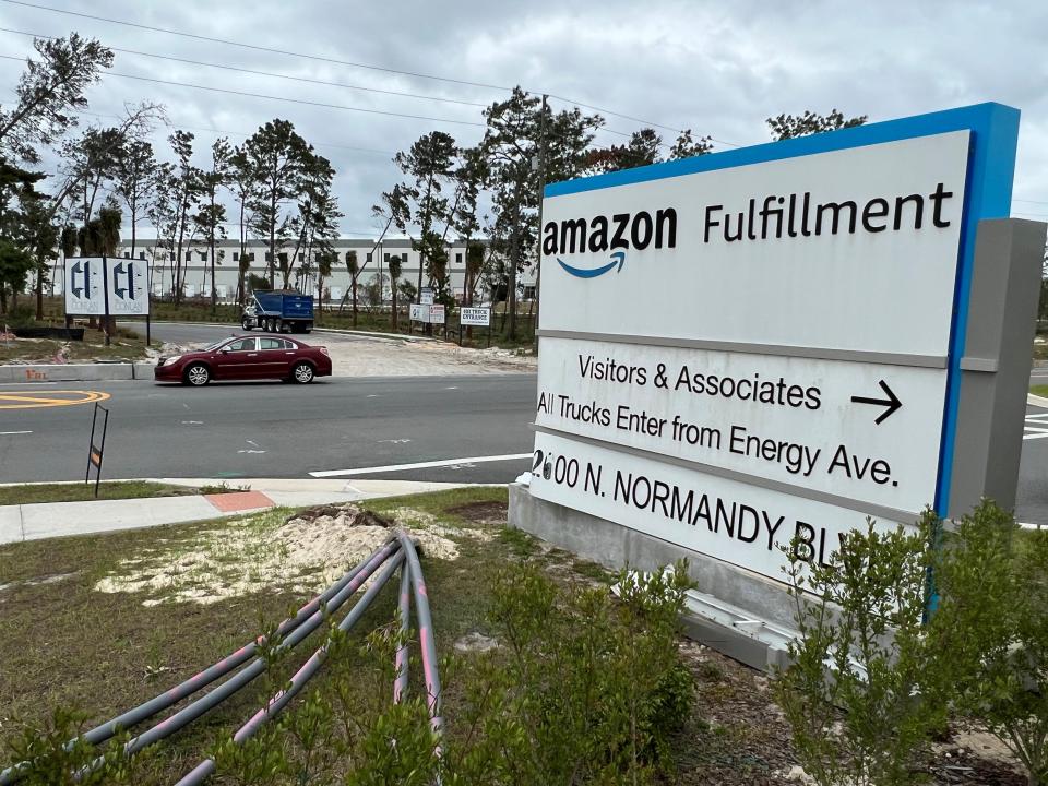 A car passes the construction site for the new I-4 Logistics Park in Deltona on Wednesday, April 12, 2023. In the foreground is a sign for the existing Amazon first-mile fulfillment center at 2600 N. Normandy Blvd. that opened in September 2020. The e-commerce giant confirmed this week that it plans to add a second facility in the recently completed building across the street (pictured in the background) that will be its first "pre-first-mile" fulfillment center in Florida.