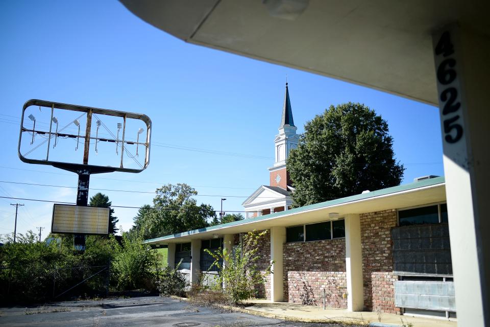 Chilhowee Hills Baptist Church towers over an abandoned Holiday Inn, 4625 Asheville Highway, in Knoxville, Tenn. on Tuesday, Oct. 19, 2021. The Knoxville City Council recently approved a $2 million grant to Lansden Landmarks to construct an 80-unit workforce housing apartment complex at the site. The existing vacant hotel will be demolished. 