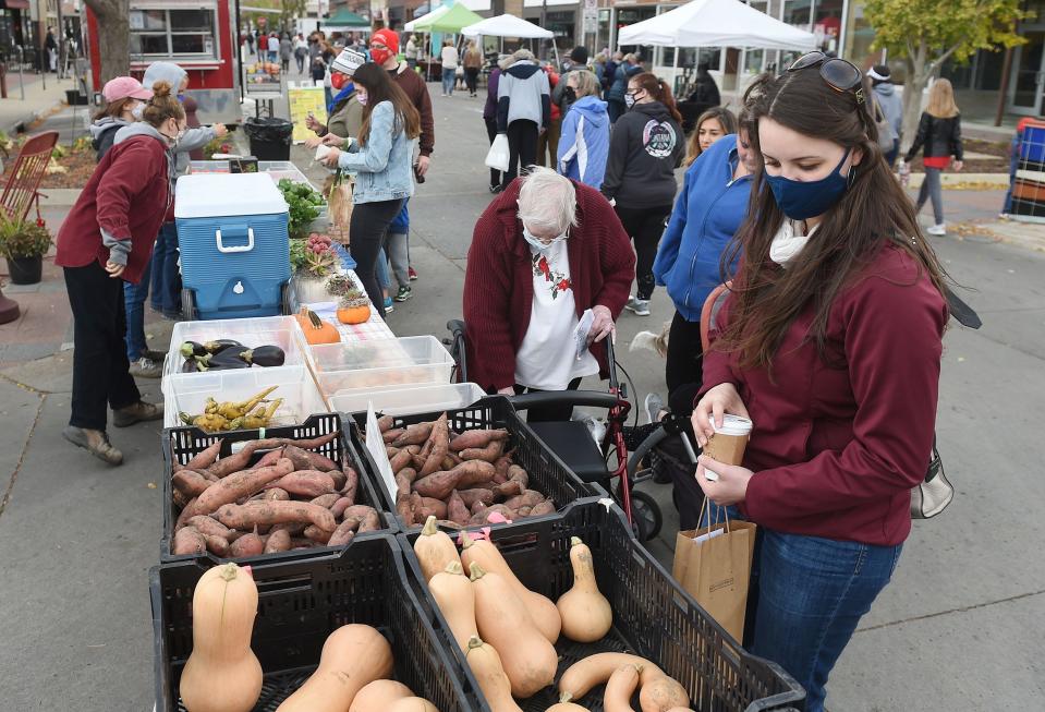 Jennifer Buehler of Ames browses vegetables at the Ames Downtown Farmers' Market on Oct. 17, 2020.