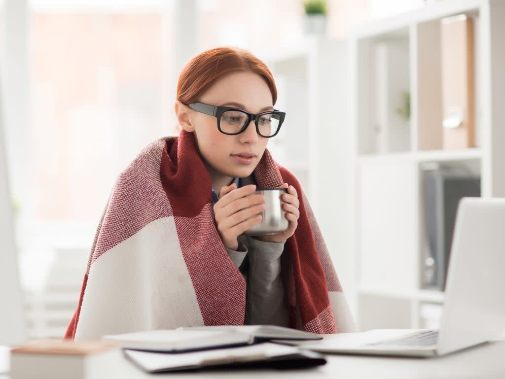 A person wears a blanket while at work (Getty Images/iStockphoto)