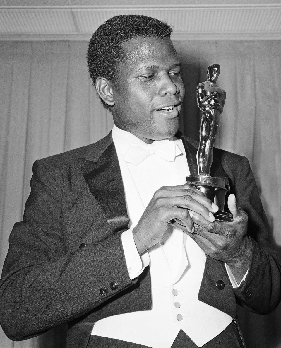 REMOVES REFERENCE TO THE BAHAMAS - FILE - Actor Sidney Poitier poses with his Oscar for best actor for "Lillies of the Field" at the 36th Annual Academy Awards in Santa Monica, Calif. on April 13, 1964. Poitier, the groundbreaking actor and enduring inspiration who transformed how Black people were portrayed on screen, became the first Black actor to win an Academy Award for best lead performance and the first to be a top box-office draw, died Thursday, Jan. 6, 2022. He was 94. (AP Photo, File)