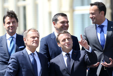 French President Emmanuel Macron gestures next to European Council President Donald Tusk as they pose for a family photo during the informal meeting of European Union leaders in Sibiu, Romania, May 9, 2019. REUTERS/Stoyan Nenov