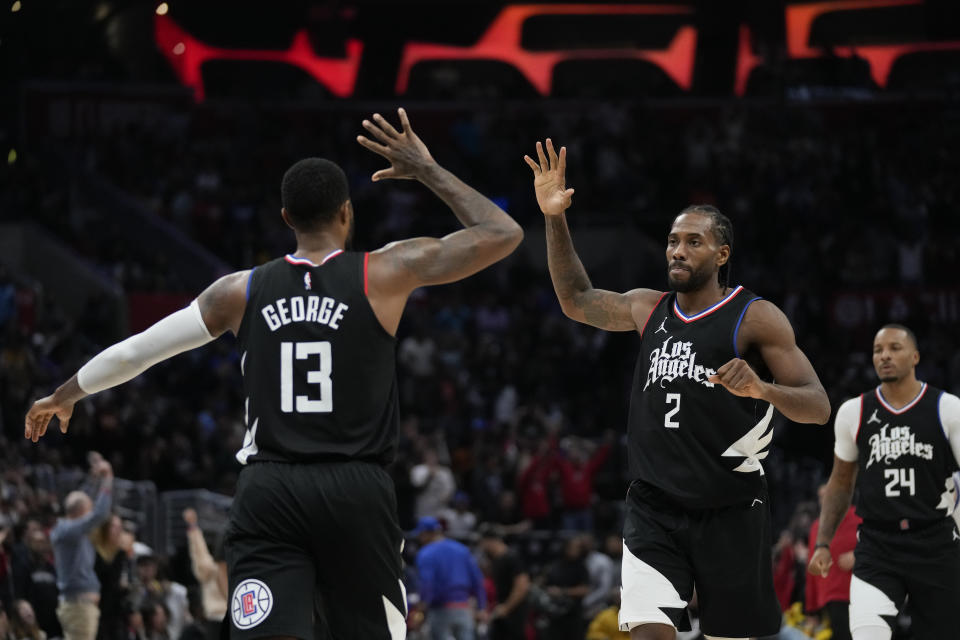 Los Angeles Clippers forward Paul George (13) celebrates with forward Kawhi Leonard (2) after scoring a 3-pointer during the second half of an NBA basketball game against the Golden State Warriors in Los Angeles, Saturday, Dec. 2, 2023. The Clippers won 113-112. (AP Photo/Ashley Landis)