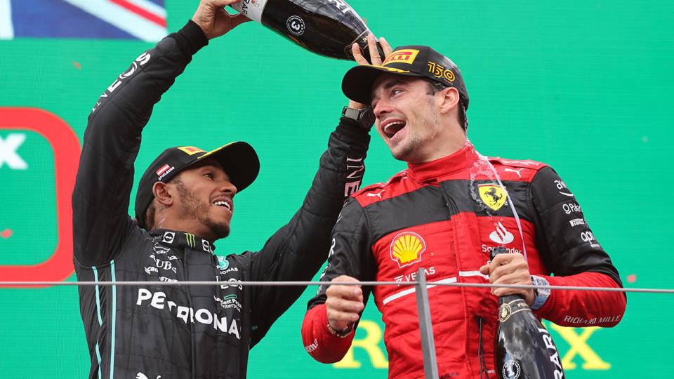 Charles Leclerc is sprayed with champagne on the Austrian GP podium by Lewis Hamilton.