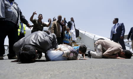 Yemenis, who were stranded in Egypt, pray as they disembark from their plane after returning home, at Sanaa international aiport May 20, 2015. REUTERS/Khaled Abdullah