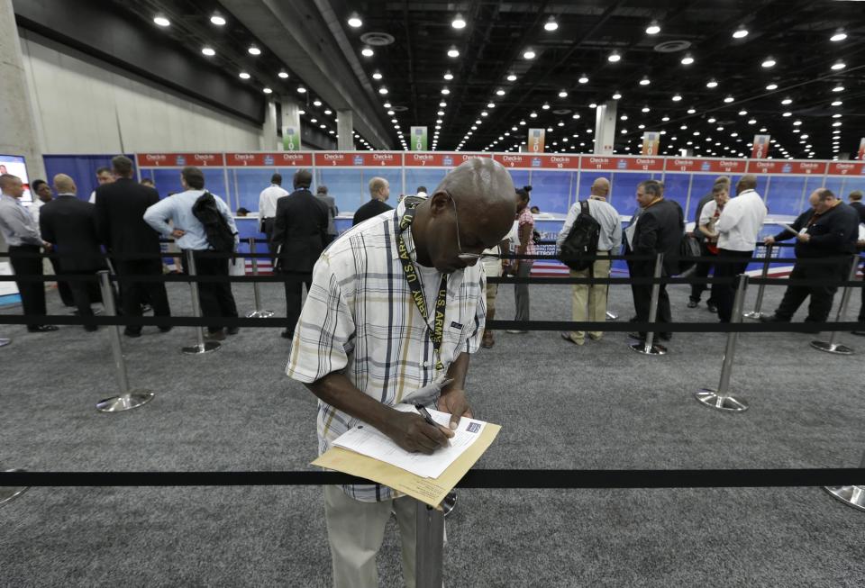 Wallace Berry, of Detroit, a military veteran fills out paperwork in line in Detroit, Tuesday, June 26, 2012 during a first-of-its-kind gathering designed to help America's warriors on a number of fronts at three events: a job fair, a small business conference and an open house. (AP Photo/Paul Sancya)