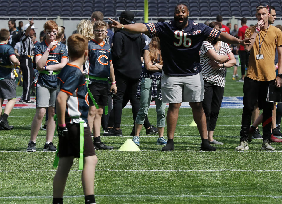 NFL Player Akiem Hicks of the Chicago Bears coaches a young team during the final tournament for the UK's NFL Flag Championship, featuring qualifying teams from around the country, at the Tottenham Hotspur Stadium in London, Wednesday, July 3, 2019. The new stadium will host its first two NFL London Games later this year when the Chicago Bears face the Oakland Raiders and the Carolina Panthers take on the Tampa Bay Buccaneers. (AP Photo/Frank Augstein)