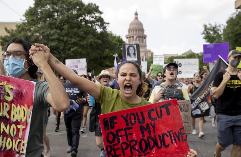 People marching and shouting for abortion rights.