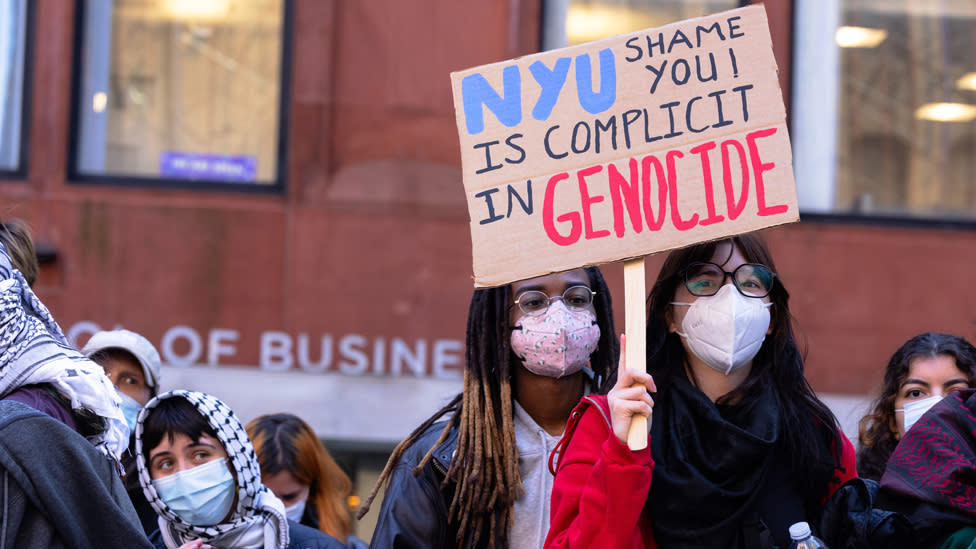 Image of two female protesters holding up a sign