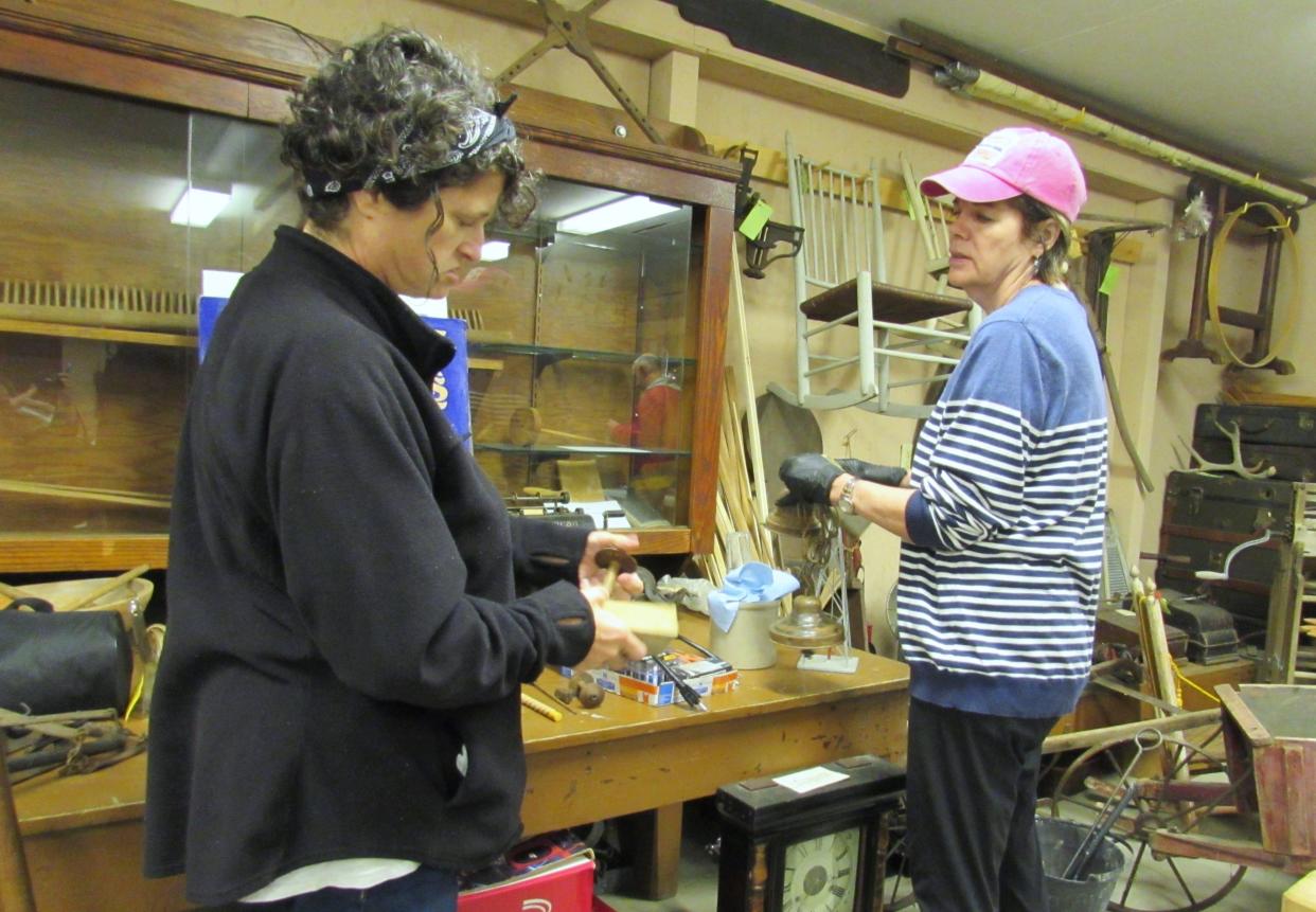 Christine Baker, left, and Elly Styles gently go over artifacts from the Heritage House with a dry sponge.