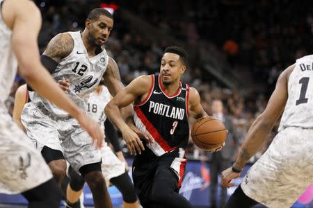 Mar 16, 2019; San Antonio, TX, USA; Portland Trail Blazers shooting guard CJ McCollum (3) drives for the basket between San Antonio Spurs power forward LaMarcus Aldridge (12) and DeMar DeRozan (right) during the first half at AT&T Center. Mandatory Credit: Soobum Im-USA TODAY Sports