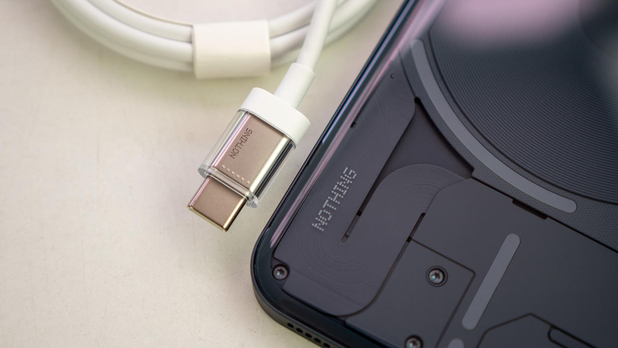  Looking closely at the back of the Nothing Phone (2) alongside the included transparent USB-C cable 