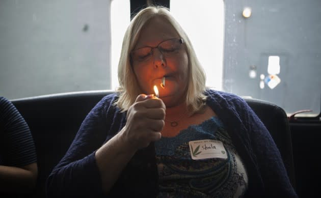 Sheila Orlovsky, 29, of Florida, lights a joint in the bus during a cannabis tour in Denver. See more photos of female-owned pot businesses <a href="http://www.theatlantic.com/photo/slideshow/women-owned-pot-businesses-change-denvers-social-use-landscape/487013/?utm_source=yahoo" rel="nofollow noopener" target="_blank" data-ylk="slk:here;elm:context_link;itc:0;sec:content-canvas" class="link ">here</a>. (Emily Jan / The Atlantic)