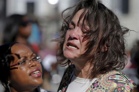 Auburn Sandstorm (R) reacts while paying her respects outside the Emanuel African Methodist Episcopal Church in Charleston, South Carolina, June 20, 2015, three days after a mass shooting left nine people dead during a bible study at the church. REUTERS/Brian Snyder