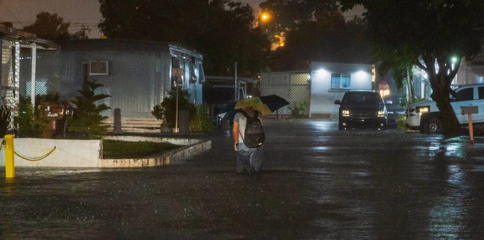 A man walks through a flooded street at the Strawberry Village Trailer Park located at West 29th Street and 16th Avenue in Hialeah as torrential downpours inundate South Florida due to a disturbance off Florida’s coast on Wednesday, November 15, 2023. Pedro Portal/pportal@miamiherald.com