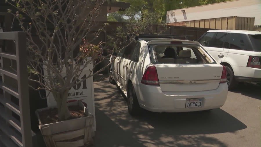A vehicle parked near the scene of the single-vehicle crash was damaged by debris flying into the area following the crash, which occurred May 11, 2024. (KTLA)
