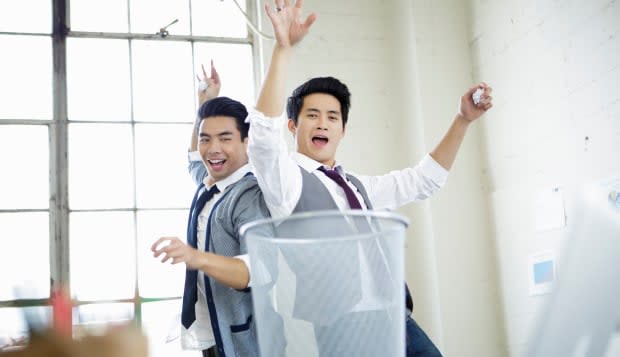 Two young men celebrating target practice in office